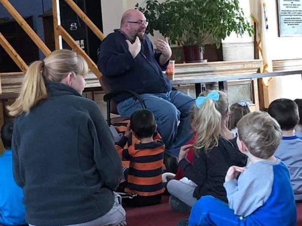 Picture of Big Ryan telling stories to children
